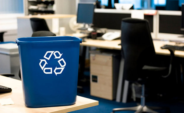 Photo of a recycling bin with a desk and workplace in the background